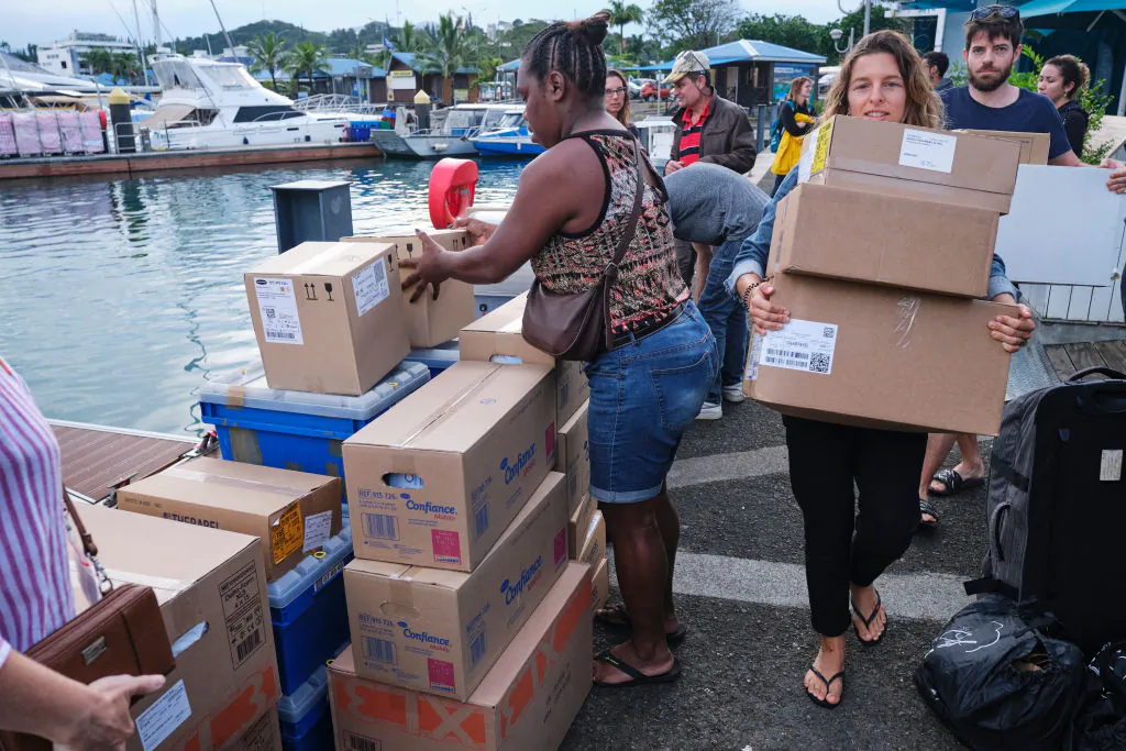 People load goods and medical aid on a boat in Noumea, New Caledonia, on June 10, 2024. (Theo Rouby/AFP via Getty Images)