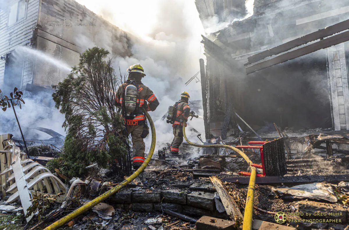 Firefighters use handlines to extinguish the fire adjacent to the primary structure involved after a small plane crashed Saturday, Aug. 31, 2024, in Fairview, Ore. (Greg Muhr/Portland Fire & Rescue via AP)