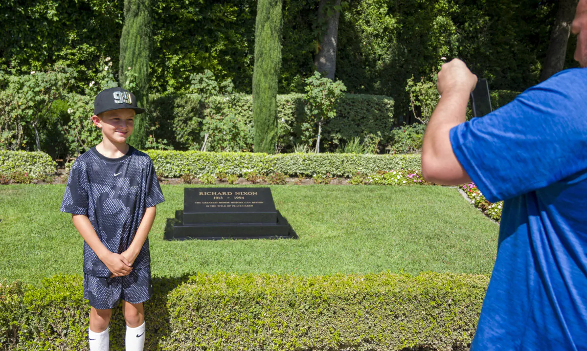 Henry Fallon, 10, left, has his photo take by his father TJ near the gravesite of President Richard Nixon at The Richard Nixon Library & Museum in Yorba Linda on Monday, Aug. 5, 2024. TJ Fallon has visited all 39 presidential gravesites and as of this week—his son Henry, 10, has also seen them all. (Leonard Ortiz/Orange County Register/TNS)