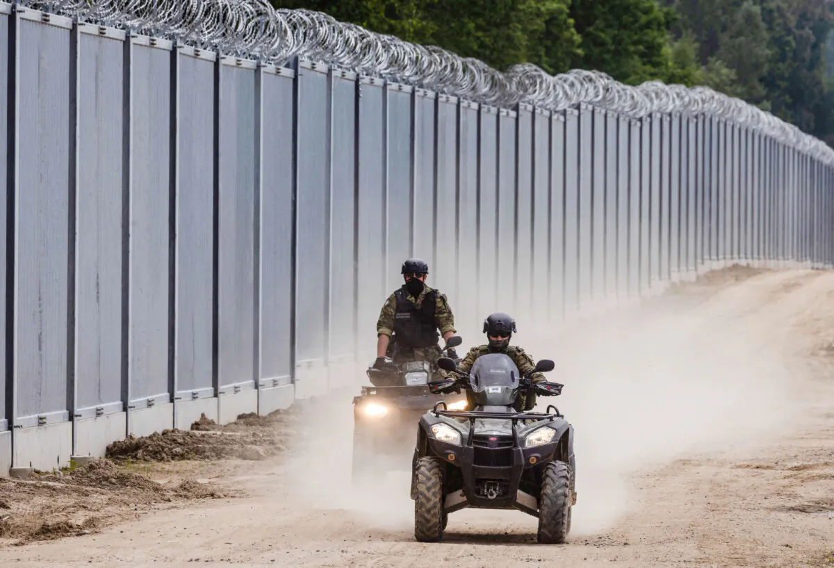Border guards patrol on all-terrain vehicles along the wall at the Poland–Belarus border in northeastern Poland on June 8, 2022. (Wojtek Radwanski/AFP via Getty Images)