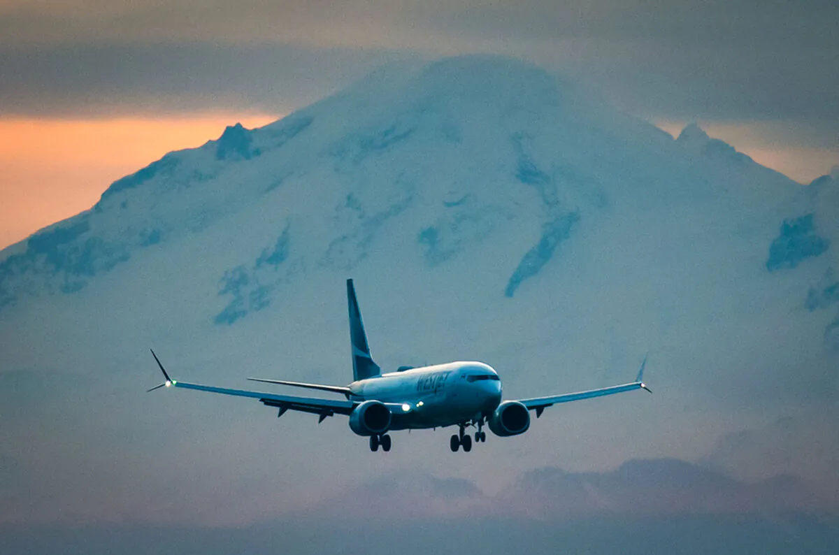 Mount Baker in Washington is seen in the distance as a WestJet Airlines Boeing 737 Max aircraft arrives at Vancouver International Airport in Richmond, B.C., on Jan. 21, 2021. (Darryl Dyck/The Canadian Press)