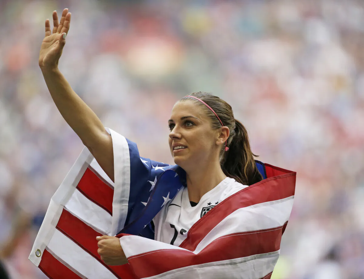 United States' Alex Morgan is draped in the U.S. flag as she waves to fans after the United States beat Japan 5–2 in the FIFA Women's World Cup soccer championship in Vancouver, British Columbia, Canada, on July 5, 2015. (Elaine Thompson/AP Photo)