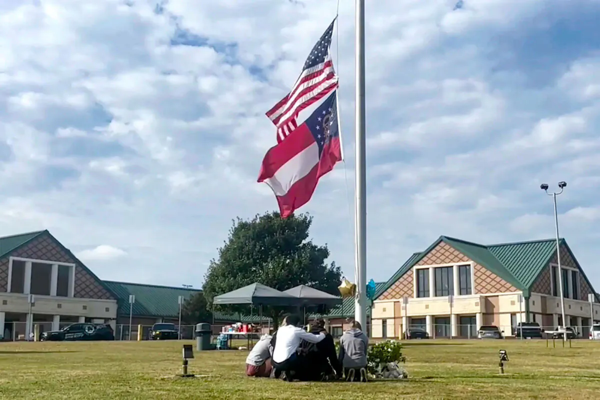 People gather at the flagpole outside the entrance to Apalachee High School in Winder, Ga., on Sept. 5, 2024, a day after deadly shootings at the school. (Sharon Johnson/AP Photo)
