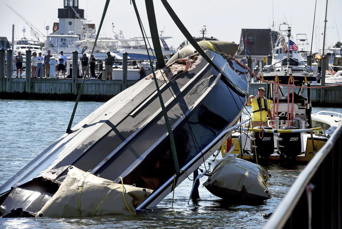 A capsized boat with a damaged hull is lifted out of the water by a Sea Tow Salvage Response Unit and Eric's Towing at Saybrook Point in Old Saybrook, Conn., on Sept. 3, 2024. (Arnold Gold/Hearst Connecticut Media via AP)