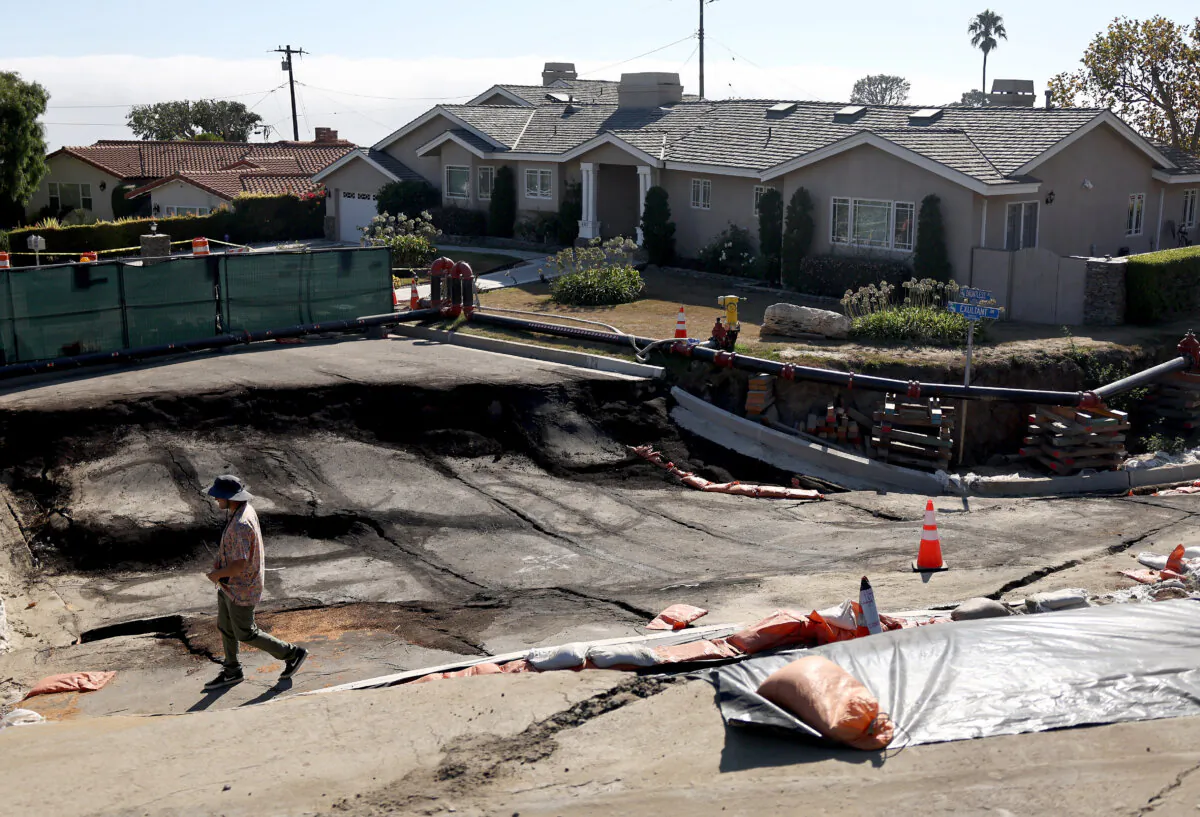A person walks along landslide damage amid an ongoing land movement crisis in the area which has forced power shutoffs to homes, with California Gov. Gavin Newsom declaring a state of emergency in Rancho Palos Verdes, Calif., on Sept. 3, 2024. (Mario Tama/Getty Images)