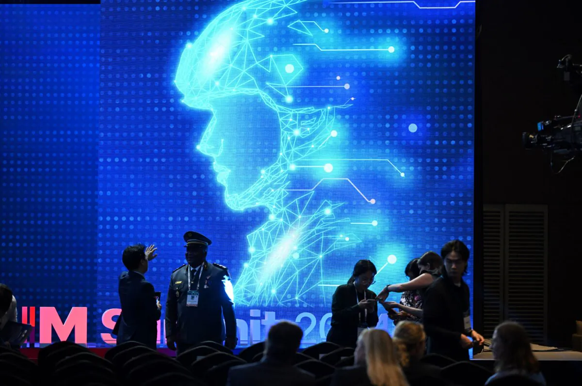 Participants chat in front of an electronic image of a soldier before the closing session of the Responsible AI in the Military Domain (REAIM) summit in Seoul on Sept. 10, 2024. Humans not artificial intelligence should make the key decisions when it comes to using nukes, a global summit AI in the military domain agreed on Sept. 10, in a non-binding declaration. (Jung Yeon-je/AFP via Getty Images)