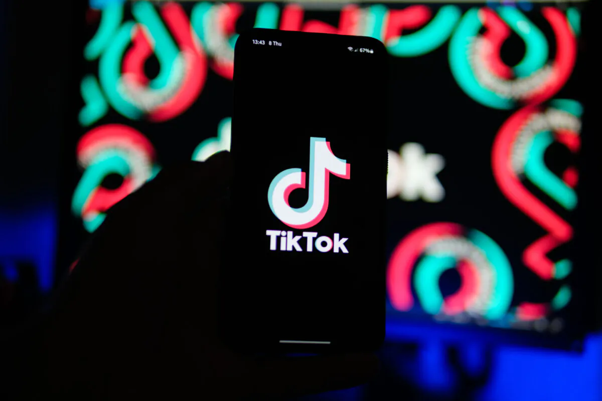A man holds a phone displaying the TikTok app on Aug. 11, 2024. (Oleksii Pydsosonnii/The Epoch Times)