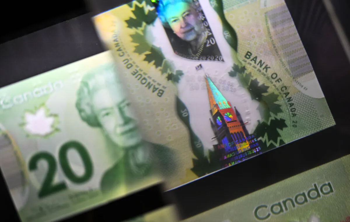 A magnifying glass enlarges the holographic image of Parliament Hill's Peace Tower on a $20 bill issued by the Bank of Canada, shown in a display case at the Bank of Canada Museum in Ottawa, on Sept. 4, 2024. (The Canadian Press/Justin Tang)
