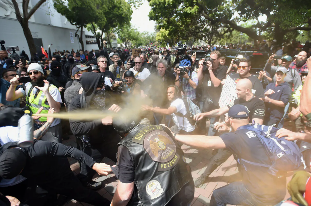 A man gets sprayed with a chemical irritant as multiple fights break out between Trump supporters and anti-Trump protesters in Berkeley, Calif., on April 15, 2017. Hundreds of people with opposing opinions on then President Donald Trump threw stones, lit fires, tossed explosives and tear gas and attacked each other with makeshift weapons. (Josh Edelson/AFP via Getty Images)