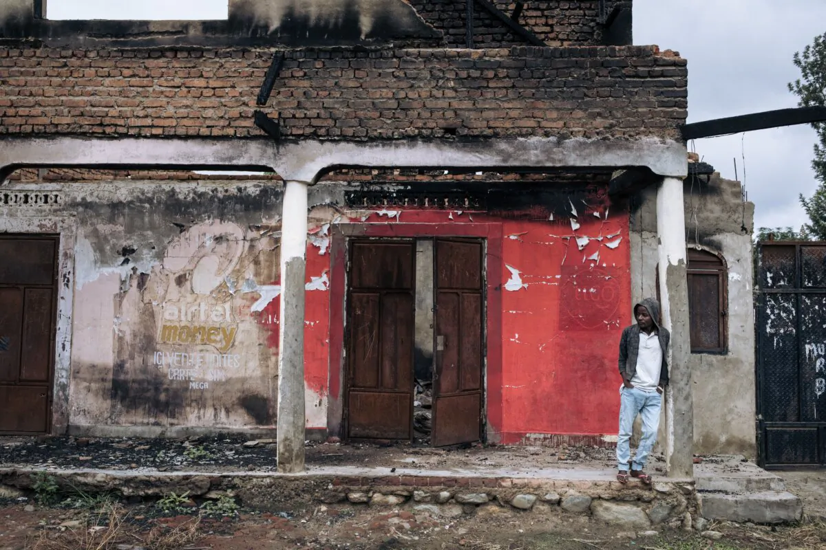 A man stands in front of the ruins of a shop looted and burned during a recent attack by an ISIS-affiliated group in Nzenga, Democratic Republic of Congo, on May 24, 2021. (Alexis Huguet/AFP via Getty Images)