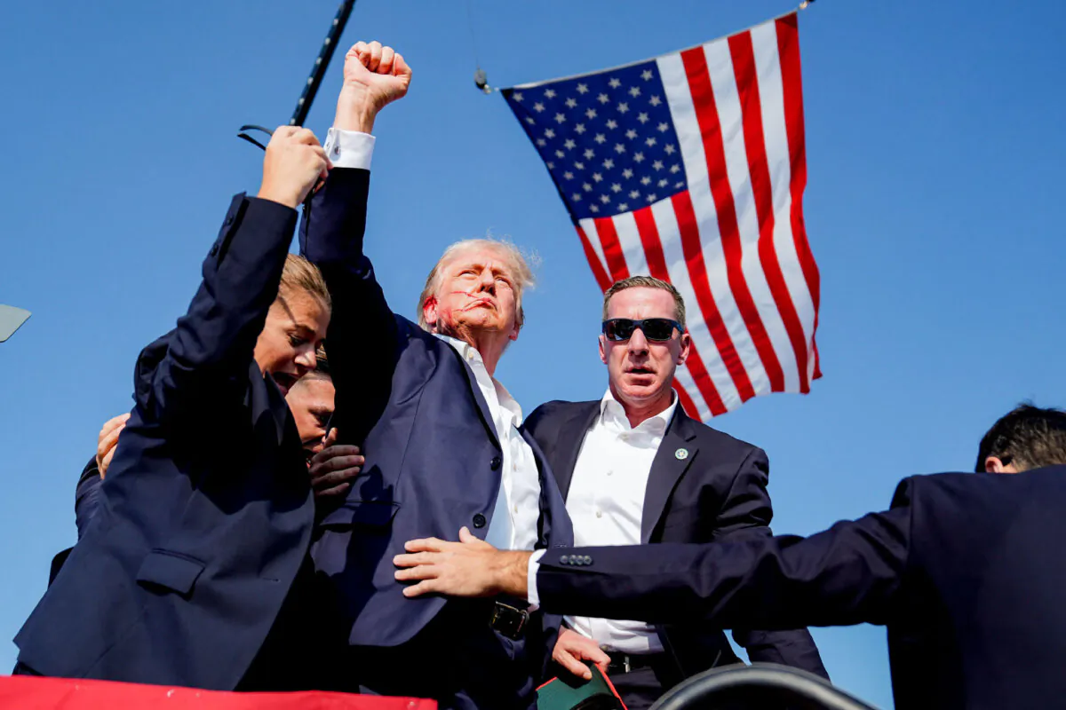 U.S. Secret Service agents rush to protect former President Donald Trump after shots were fired during a campaign rally in Butler, Pa., on July 13, 2024. (Evan Vucci/AP Photo)