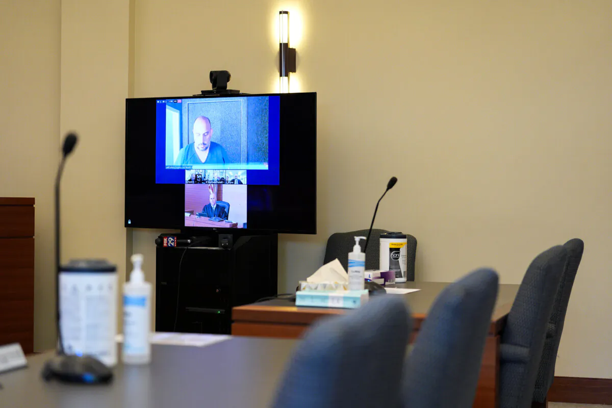Sean M. Higgins, top, the alleged drunken driver charged with killing NHL hockey player Johnny Gaudreau and his brother Matthew as they bicycled on a rural road, appears before Judge Michael Silvanio, bottom, for his hearing via video from jail, in Woodbury, N.J., on Sept. 13, 2024. (Derik Hamilton/AP Photo)