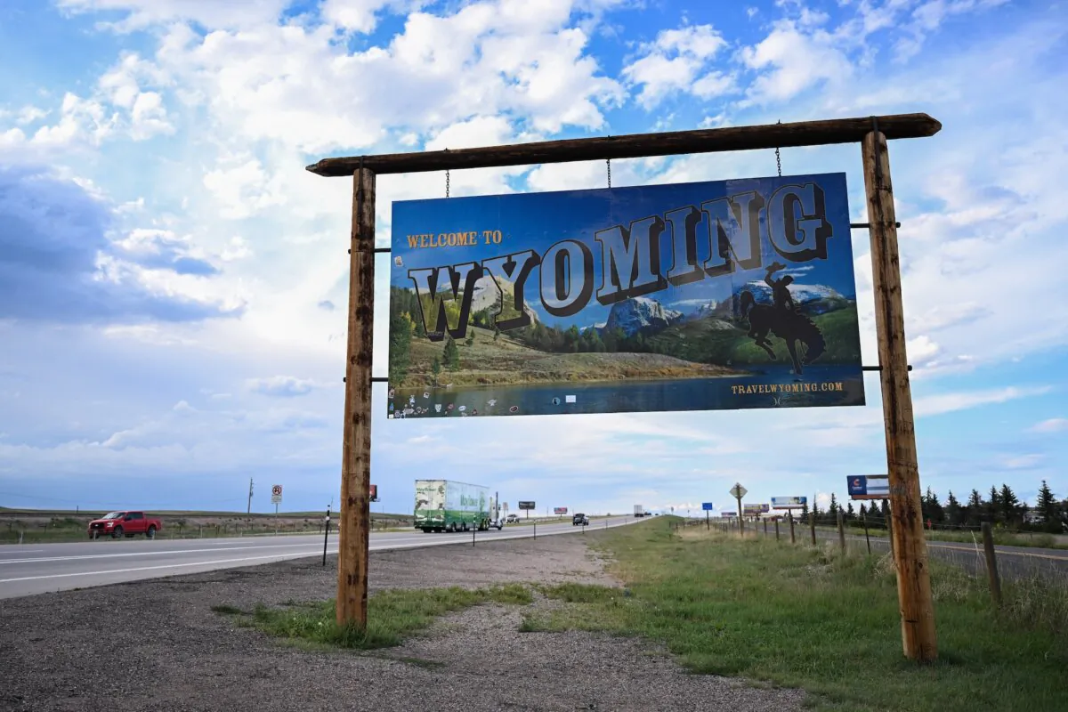 Vehicles pass a welcome sign along I-25, south of Cheyenne, Wyo., on Aug. 12, 2022. (Patrick T. Fallon/AFP)