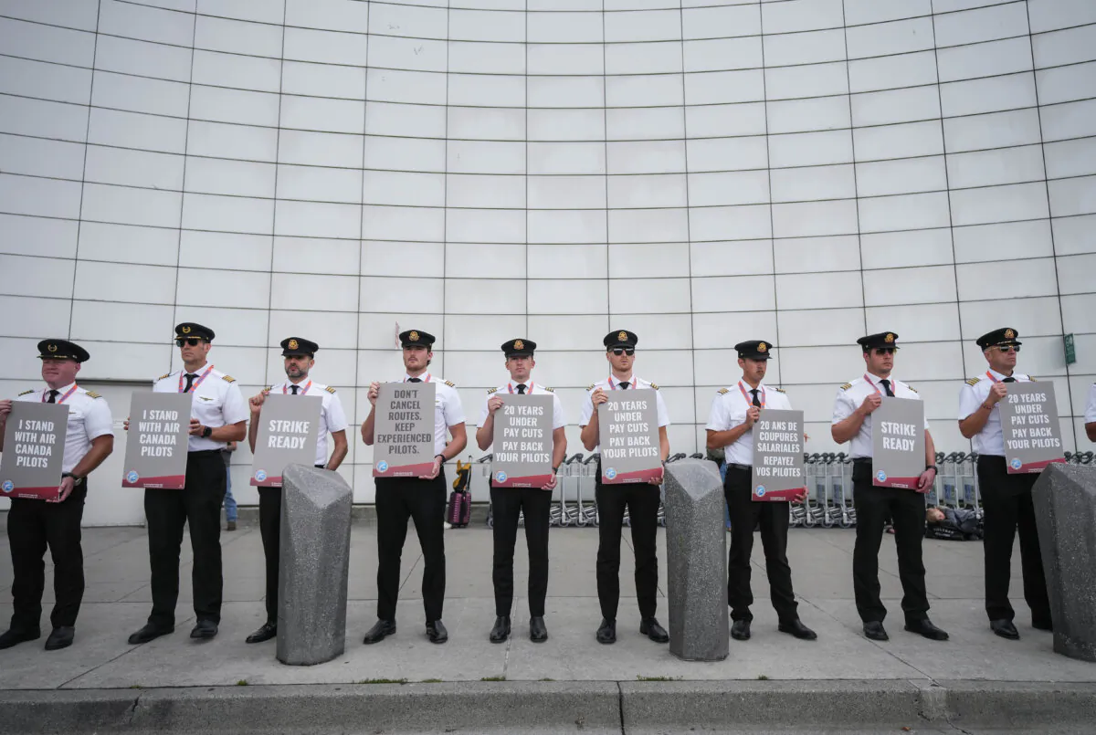 Air Canada pilots hold signs during an informational picket at Vancouver International Airport in Richmond, B.C., on Aug. 27, 2024. (The Canadian Press/Darryl Dyck) 