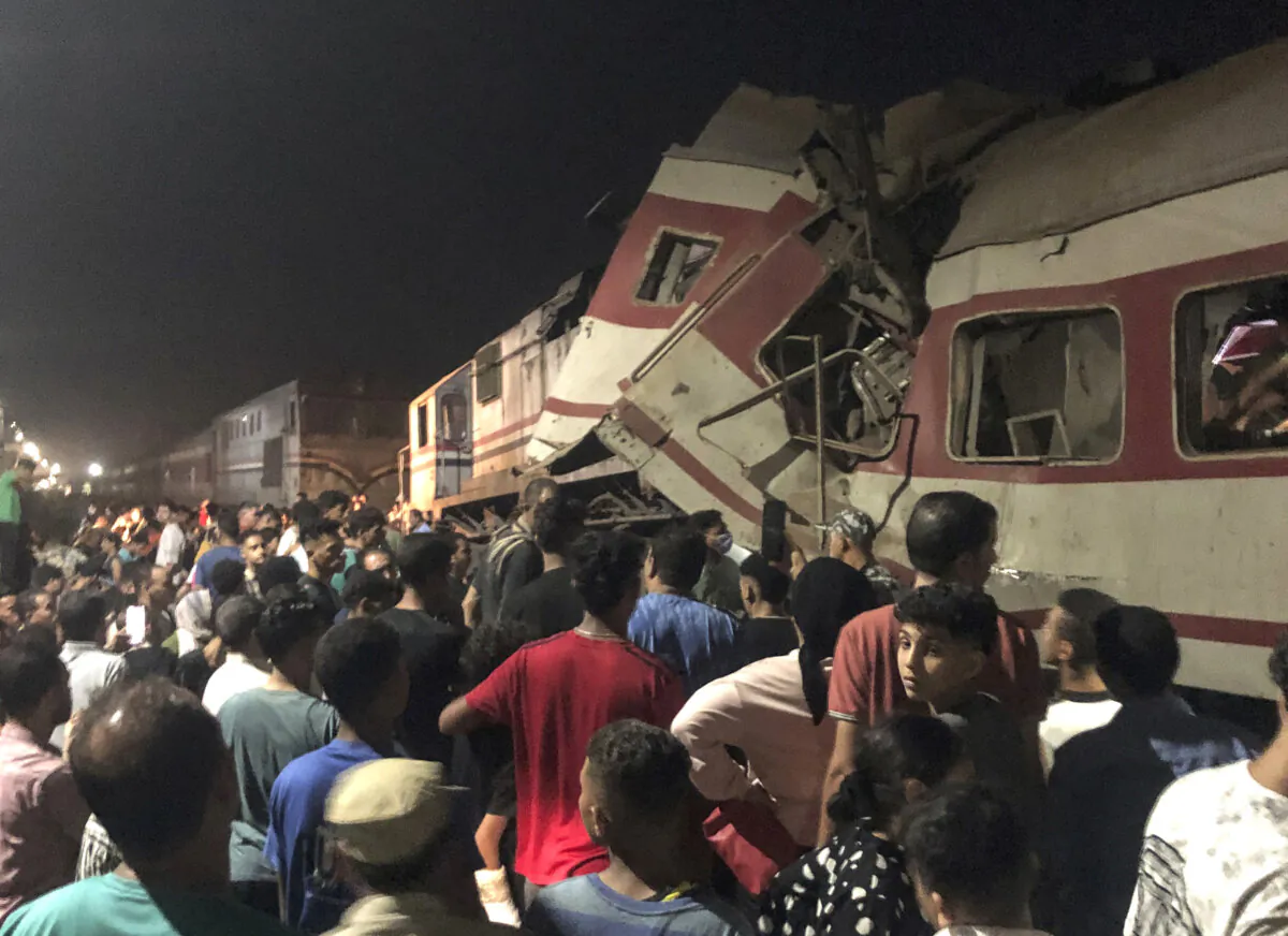 People surround two passenger trains which collided in Egypt's Nile Delta city of Zagazig, the provincial capital of Sharqiya province, on Sept. 14, 2024. (AP Photo)