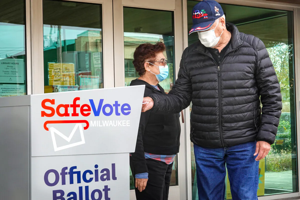 Residents drop mail-in ballots in an official ballot box outside a library in Milwaukee on Oct. 20, 2020. (Scott Olson/Getty Images)