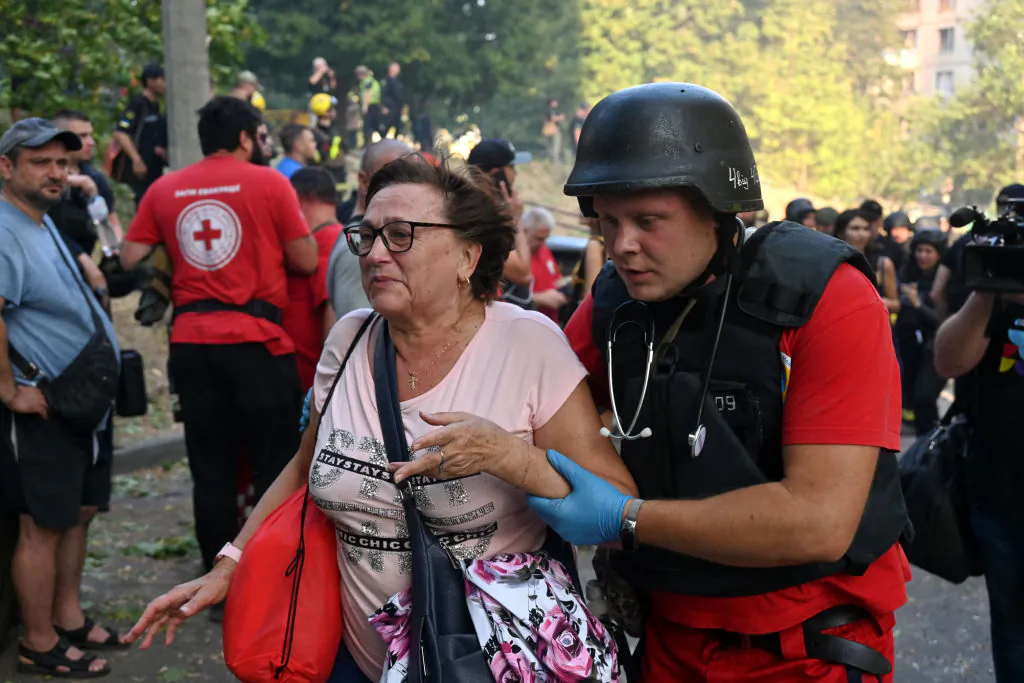 A Ukrainian medic helps a woman to leave the site of a missile attack in Kharkiv on Sept. 15, 2024, amid the Russian invasion of Ukraine. (Sergey Bobok/AFP via Getty Images)