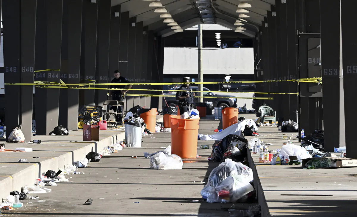 Officers stand behind police tape at the scene of a shooting at Shed 6 at Eastern Market in Detroit on Sept. 15, 2024. (Robin Buckson/Detroit News via AP)