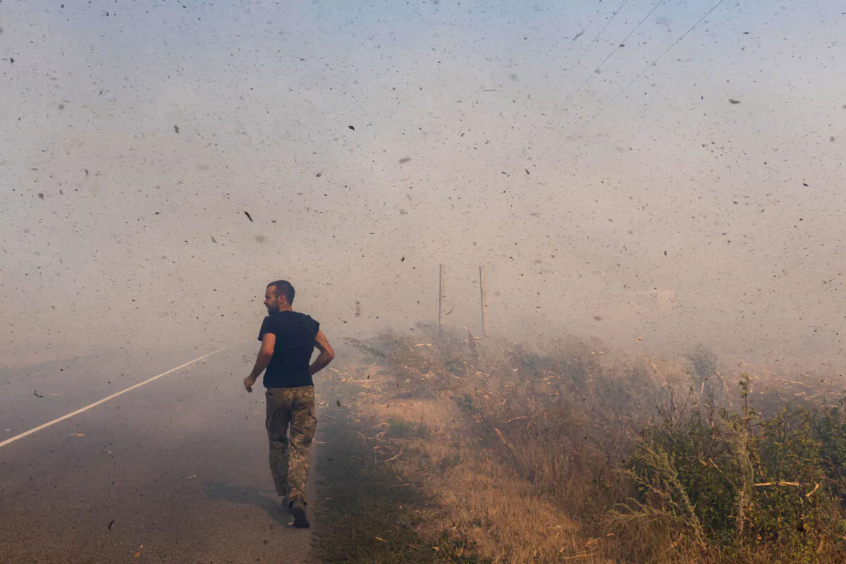 A Ukrainian serviceman runs to help farmers extinguish a burning field near Pokrovsk, Donetsk region, amid the Russian invasion of Ukraine, on Sept. 16, 2024. (Oleksii Filippov/AFP via Getty Images)