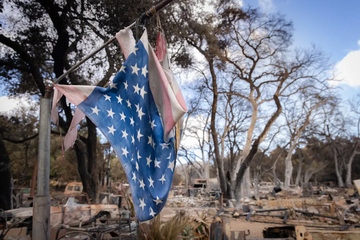 An American flag blows amid the damage left over from the Airport Fire in El Cariso Village, Calif., on Sep. 16, 2024. (John Fredricks/The Epoch Times)