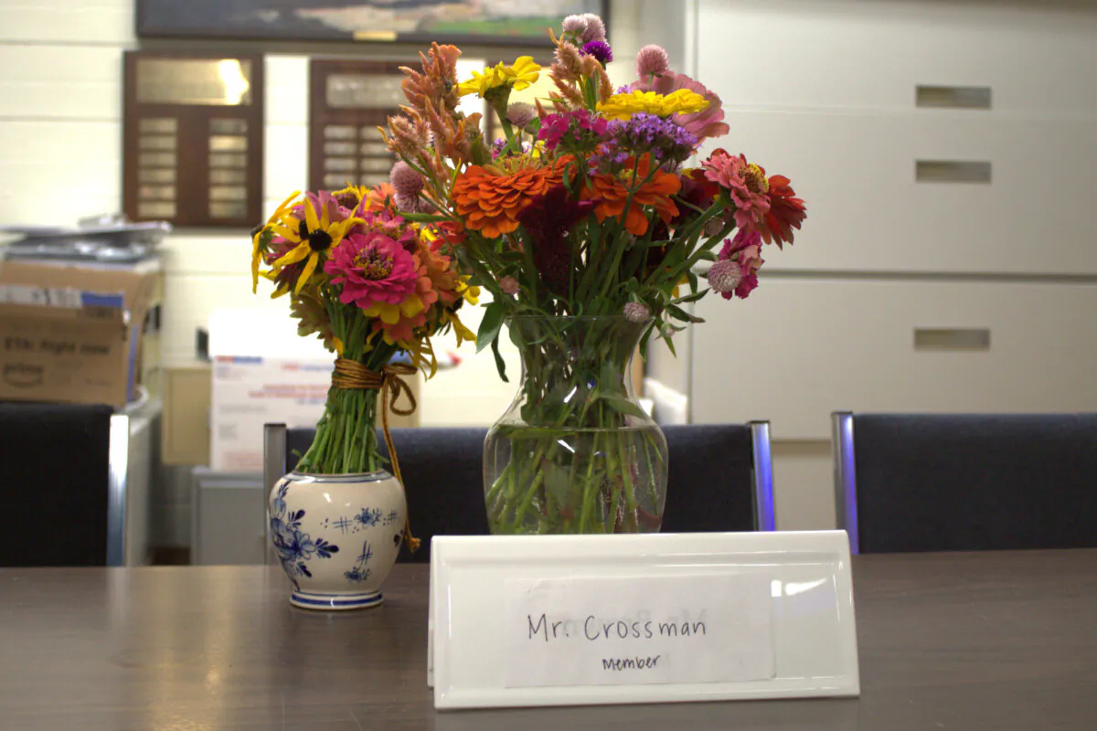Flowers rest on a table where slain Pawlet Selectboard member Brian Crossman, who along with his wife and son were found shot to death in their home over the weekend, usually sat during meetings, in Pawlet, Vt., on Sept. 17, 2024. (Cherise Forbes/Vermont News & Media via AP)