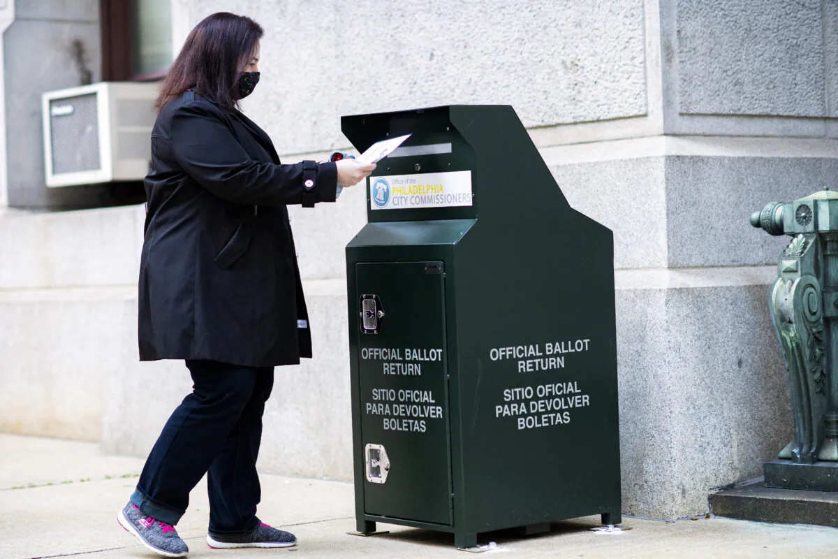 A voter casts her early voting ballot at drop box outside of City Hall in Philadelphia, Pa., on Oct. 17, 2020. (Mark Makela/Getty Images)