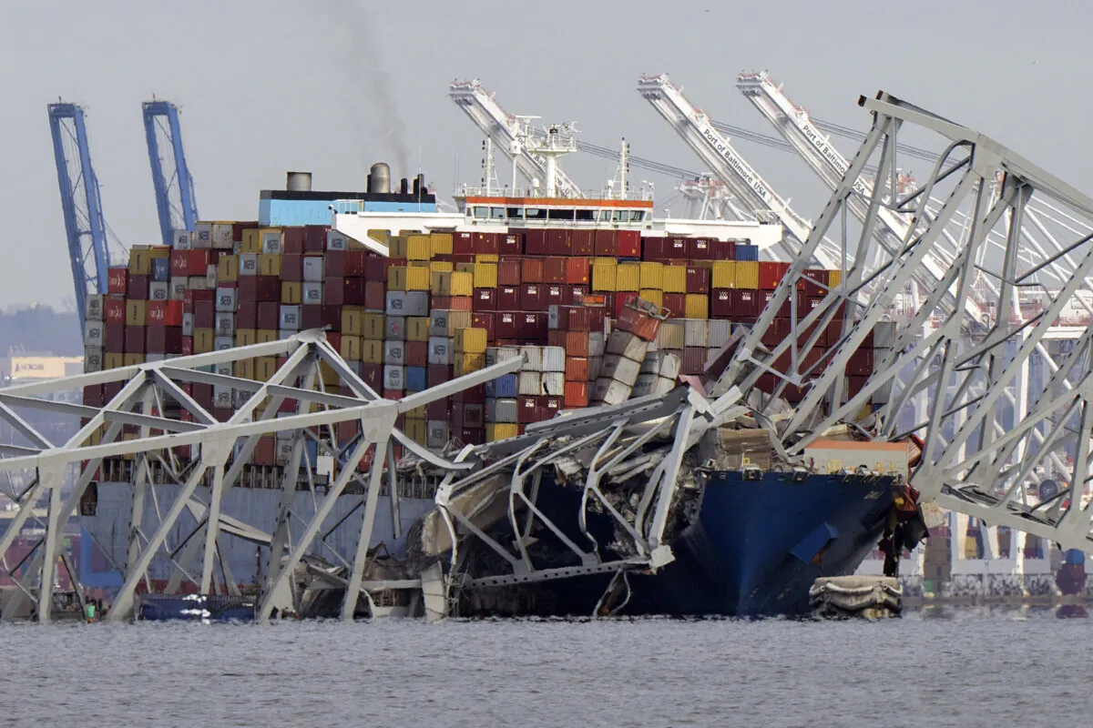 The cargo ship Dali is stuck under part of the structure of the Francis Scott Key Bridge after the ship hit the bridge, as seen from Pasadena, Md., on March 26, 2024. (Mark Schiefelbein/AP Photo)