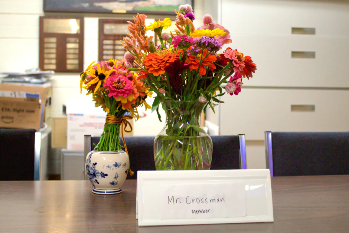 Flowers rest on a table where slain Pawlet Selectboard member Brian Crossman, who along with his wife and son were found shot to death in their home over the weekend, usually sat during meetings, in Pawlet, Vt., on Sept. 17, 2024. (Cherise Forbes/Vermont News & Media via AP)