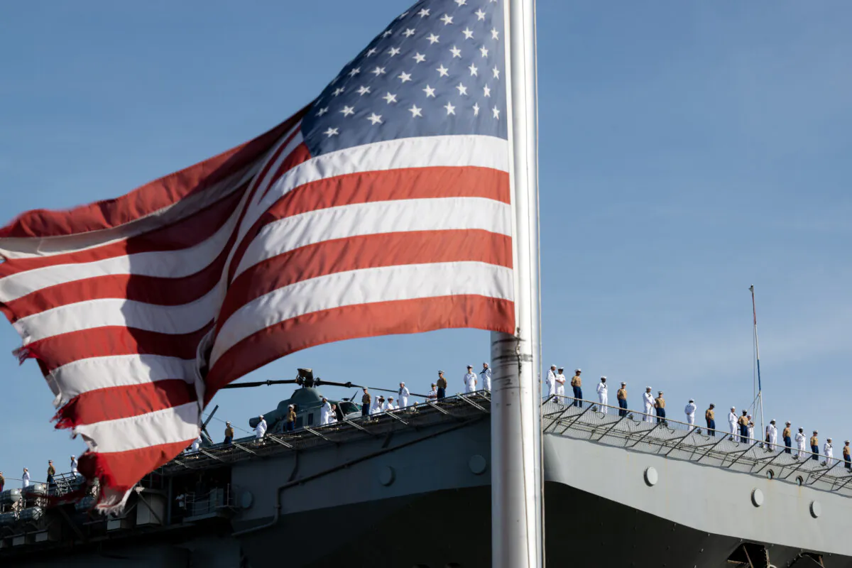 An American flag is seen as Marines and Navy sailors of the USS Bataan stand on its flight deck during their arrival for Fleet Week 2022 in New York City on May 25, 2022. (Alexi J. Rosenfeld/Getty Images)