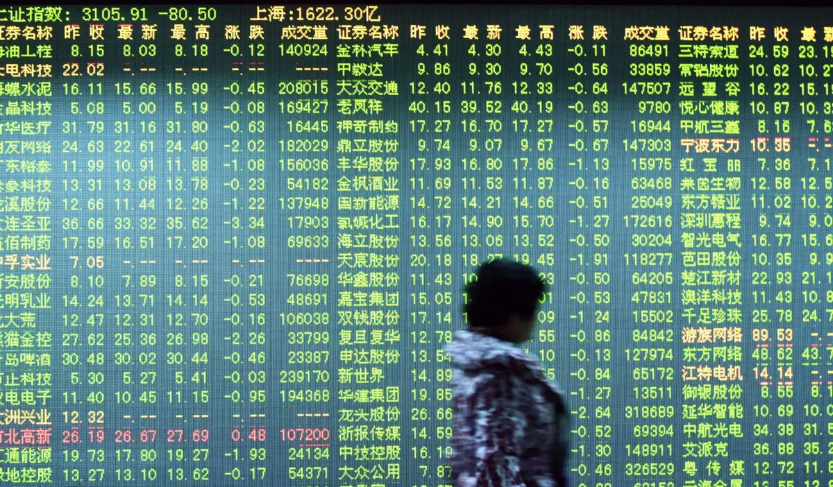 An investor walks past a screen showing stock market movements at a securities firm in Hangzhou, in eastern China's Zhejiang province, in a file photo. (STR/AFP via Getty Images)