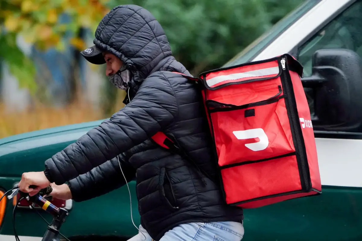 A DoorDash courier rides his bike in the rain during the COVID-19 pandemic in Manhattan, New York, on Nov. 13, 2020. (Carlo Allegri/Reuters)
