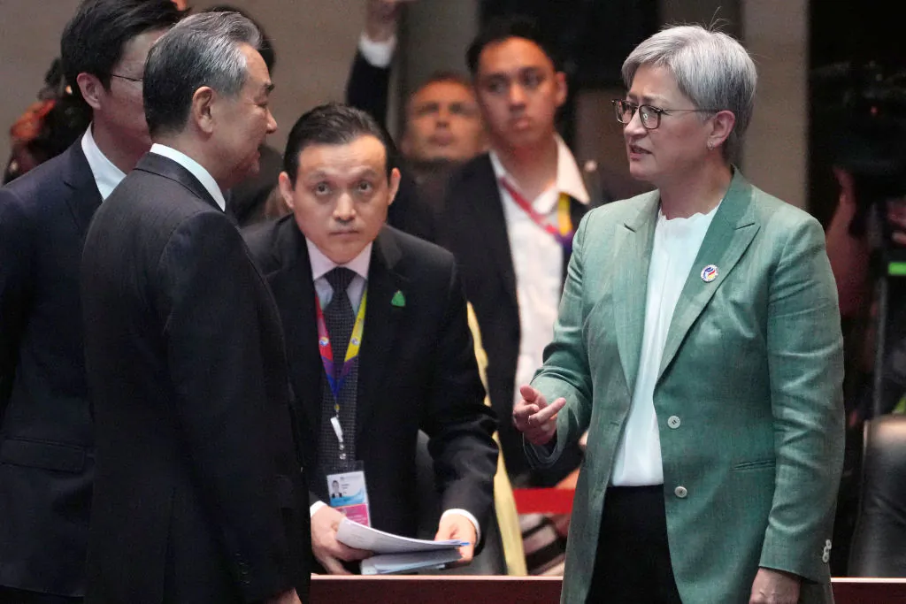 China's Foreign Minister Wang Yi (L) speaks with Australia's Foreign Minister Penny Wong (R) during the 14th East Asia Summit Foreign Ministers' Meeting at the 57th Association of Southeast Asian Nations (ASEAN) Foreign Ministers' Meeting in Vientiane on July 27, 2024. (Achmad Ibrahim/POOL/AFP via Getty Images)