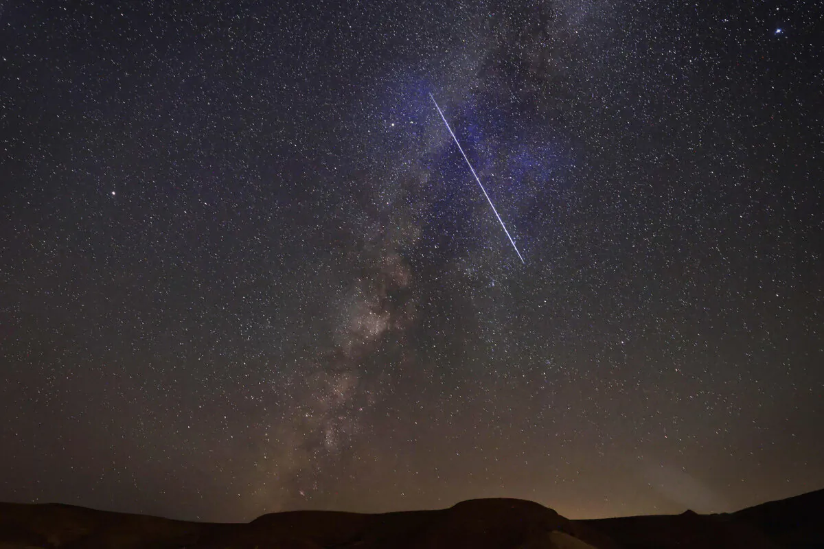 The Milky Way galaxy is pictured as a meteor streaks across the sky above the Negev desert near the Israeli city of Mitzpe Ramon. (MENAHEM KAHANA/AFP via Getty Images) (YASSER AL-ZAYYAT / AFP)