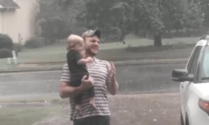 Baby Plays in Summer Rain With Father