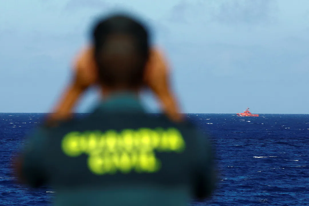 A Civil Guard officer watches a rescue boat searching for possible survivors after the sinking of a wooden boat with migrants near the port of La Restinga, on the island of El Hierro, Spain, on Sept. 28, 2024. (Borja Suarez/Reuters)