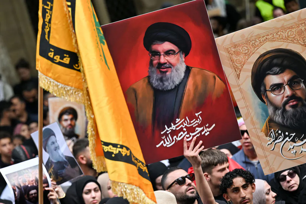 Demonstrators hold flags and pictures of Hassan Nasrallah, late leader of the Lebanese group Hezbollah, at a protest rally in the central business district of Sydney, Australia on Sept. 29, 2024. (Saeed Khan/AFP via Getty Images)