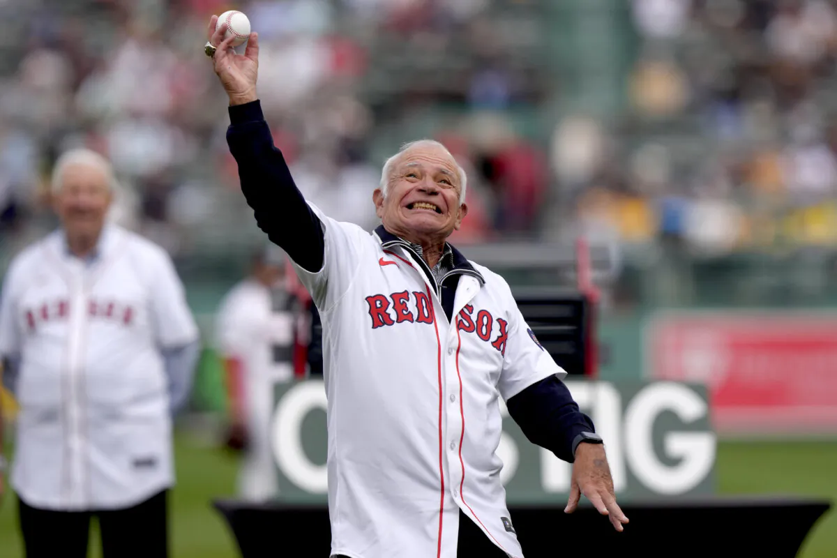 Joe Castiglione (L), radio voice of the Boston Red Sox since 1983, throws out a ceremonial first pitch during pregame ceremonies for Castiglione, before the Tampa Bay Rays played the Red Sox in a baseball game, in Boston on Sept. 29, 2024. (Steven Senne/AP Photo)