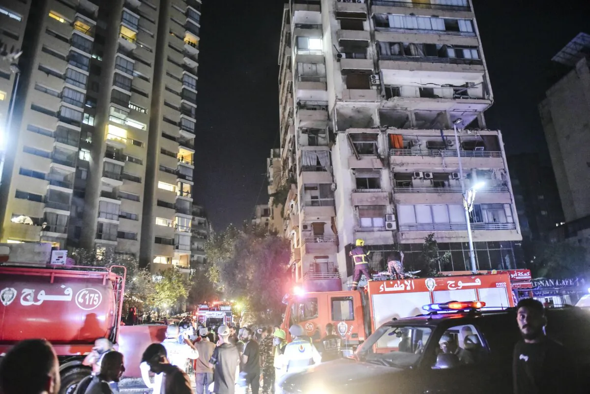 Firefighters gather at the site of an apartment building hit by an Israeli air strike in Beirut's Cola district, Lebanon, on Sept. 30, 2024. (FADEL ITANI/AFP via Getty Images)