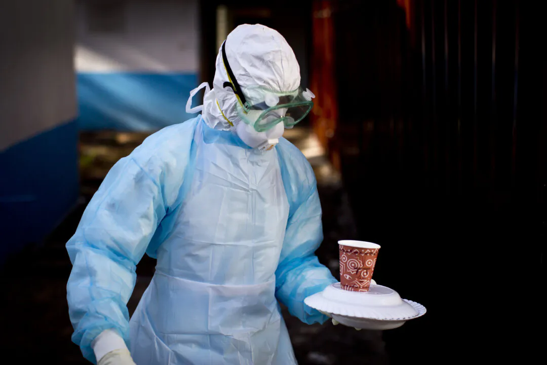 In a file photograph, a medical worker from the Infection Prevention and Control unit wearing full protective equipment carries a meal to an isolation tent housing a man being quarantined after coming into contact with a carrier of the Marburg Virus, at the Kenyatta National Hospital in Nairobi, Kenya. (Ben Curtis/AP Photo)
