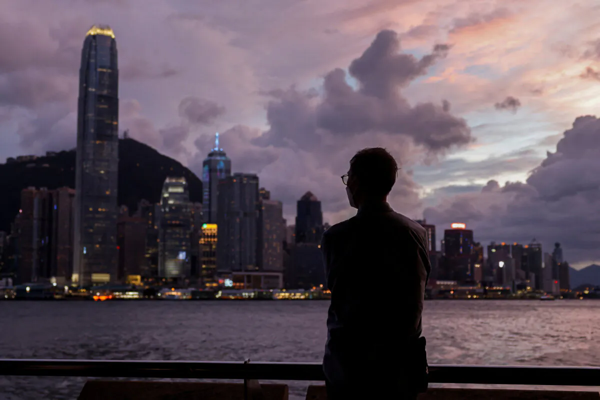 A man stands in front of Victoria Harbour, with the Central financial district in the background, in Hong Kong on Sept. 5, 2024. (Tyrone Siu/Reuters)
