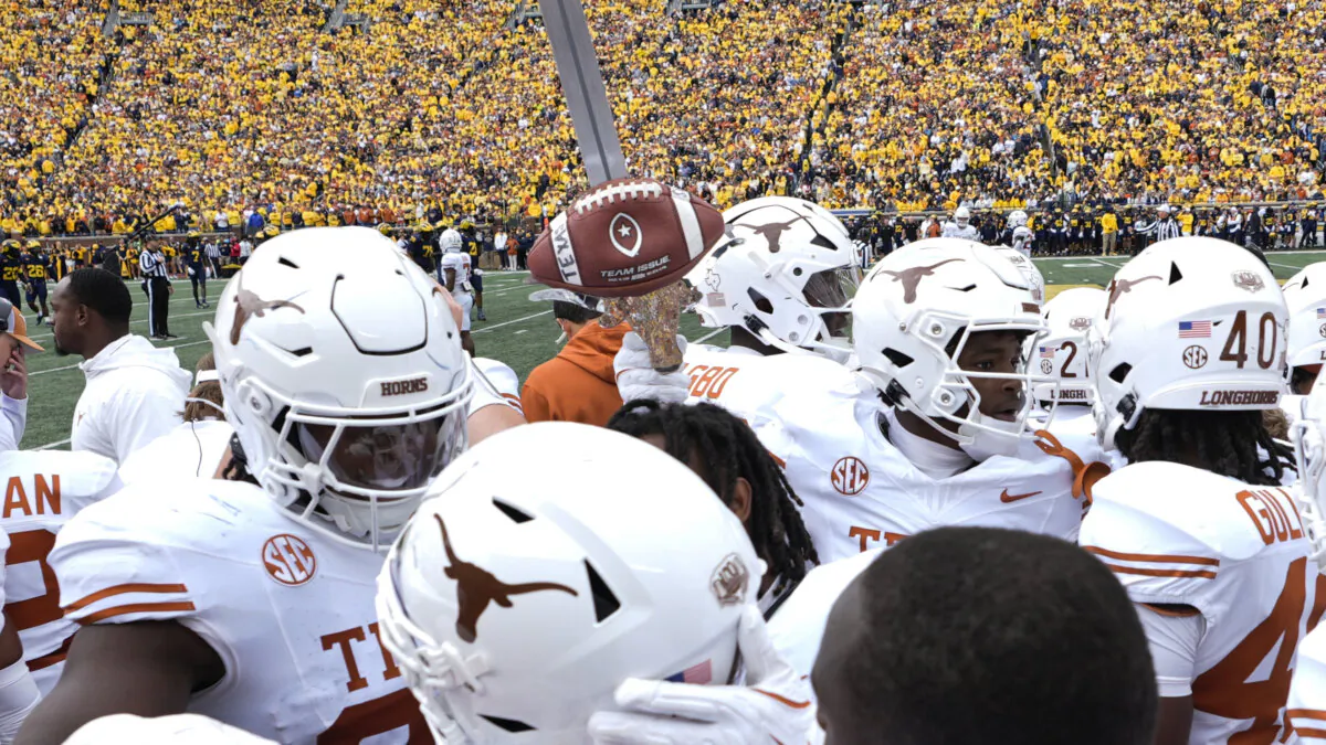 Texas defensive back Andrew Mukuba celebrates his interception with the turnover sword against Michigan in the first half of an NCAA college football game in Ann Arbor, Mich., on Sept. 7, 2024. (Paul Sancya/AP Photo)