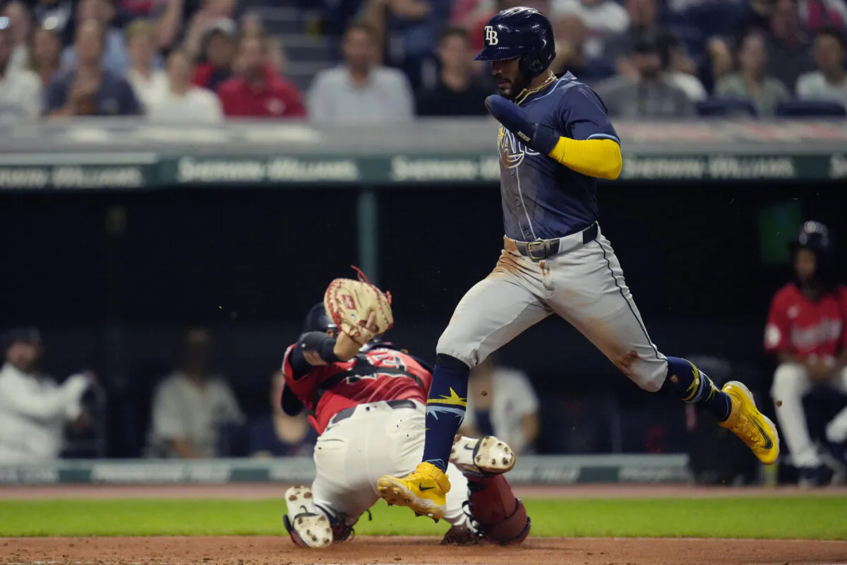 Tampa Bay Rays' José Caballero, right, scores behind Cleveland Guardians catcher Bo Naylor, left, in the fourth inning of a baseball game in Cleveland, on Sept. 12, 2024. (Sue Ogrocki/AP Photo)