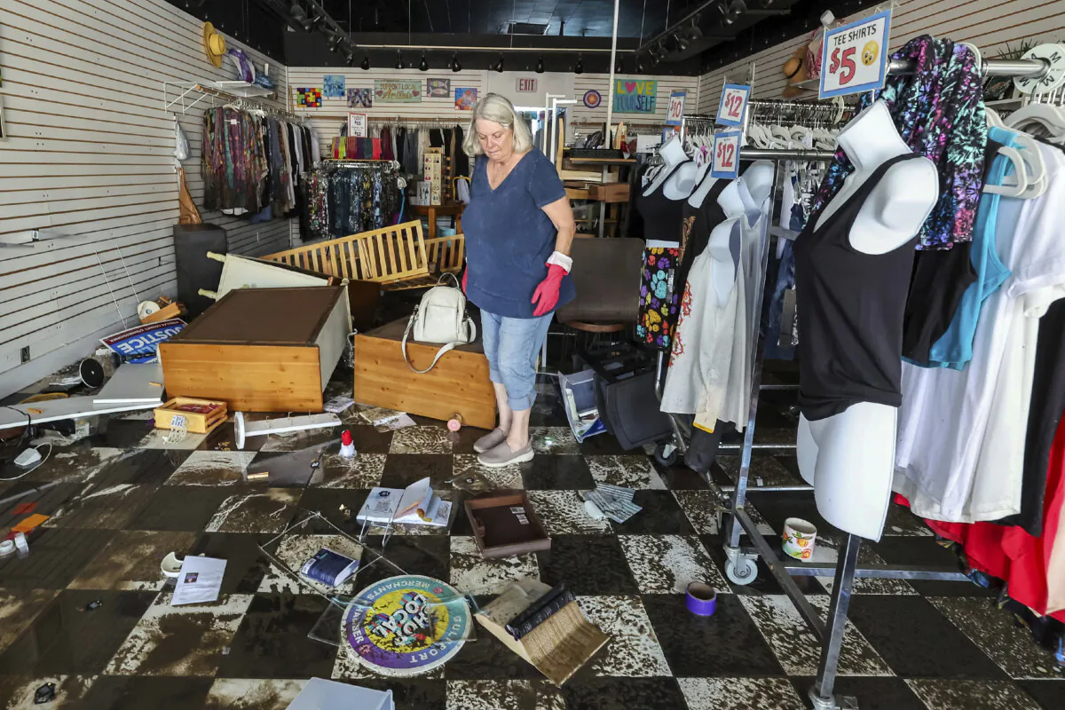 Jill Rice looks over the damage to her store caused by flooding from Hurricane Helene in Gulfport, Fla., on Sept. 27, 2024. (Mike Carlson/AP Photo)