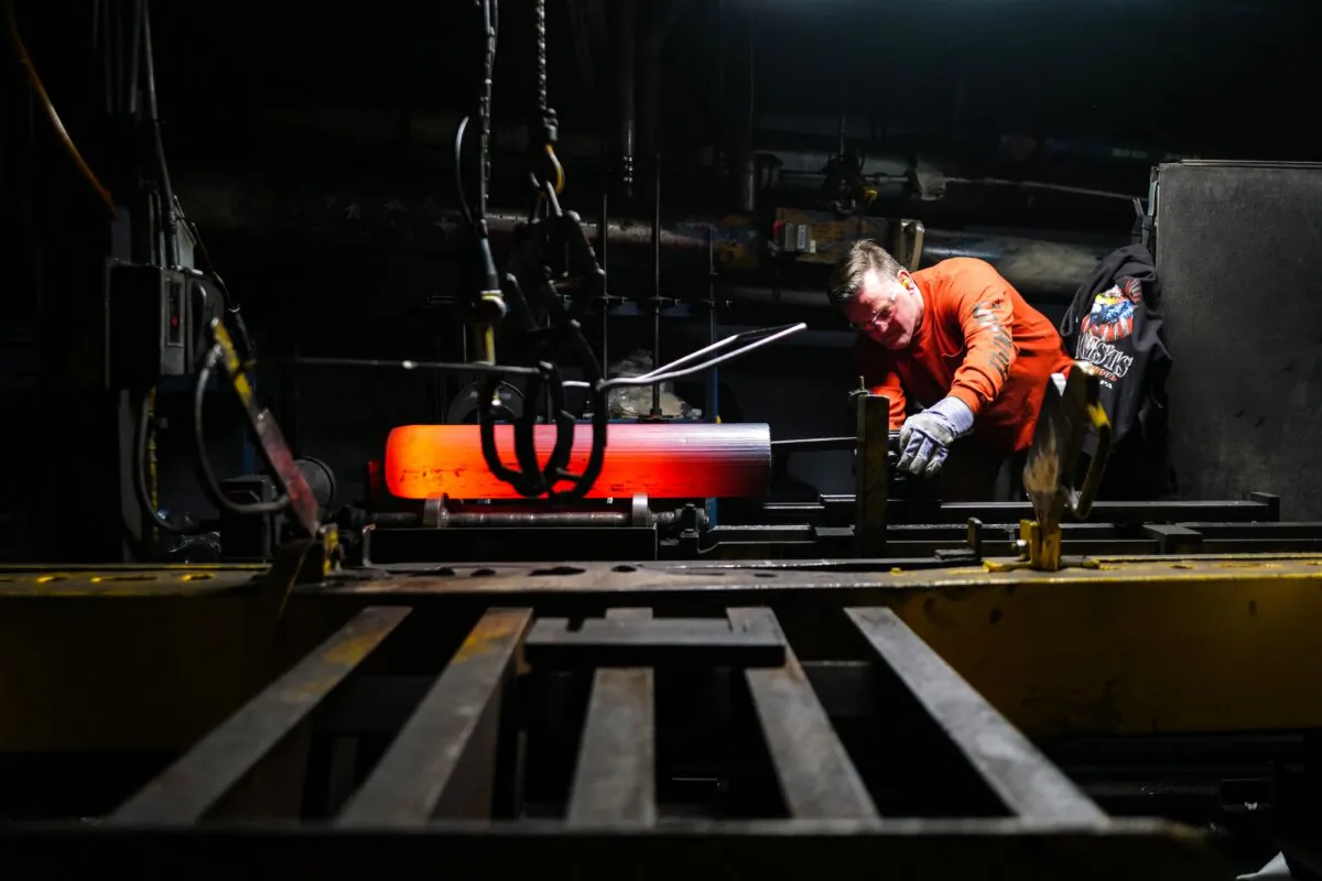 A worker inspects the form of the shaped steel billets following the "press" stage in the manufacturing process of 155 mm caliber shells at the Scranton Army Ammunition Plant (SCAAP) in Scranton, Pa., on April 16, 2024. (Charly Triballeau/AFP via Getty Images)