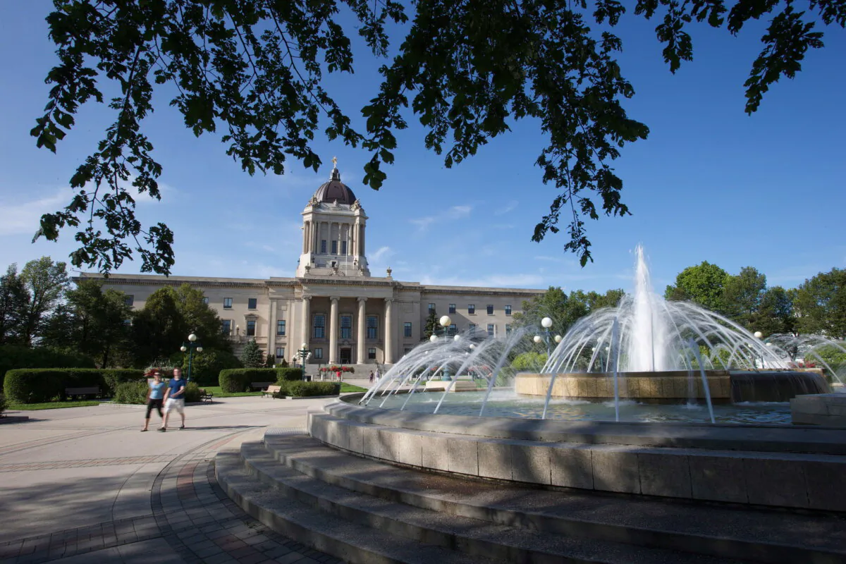People walk on the grounds of the Manitoba legislature in Winnipeg, in a file photo. (The Canadian Press/John Woods)