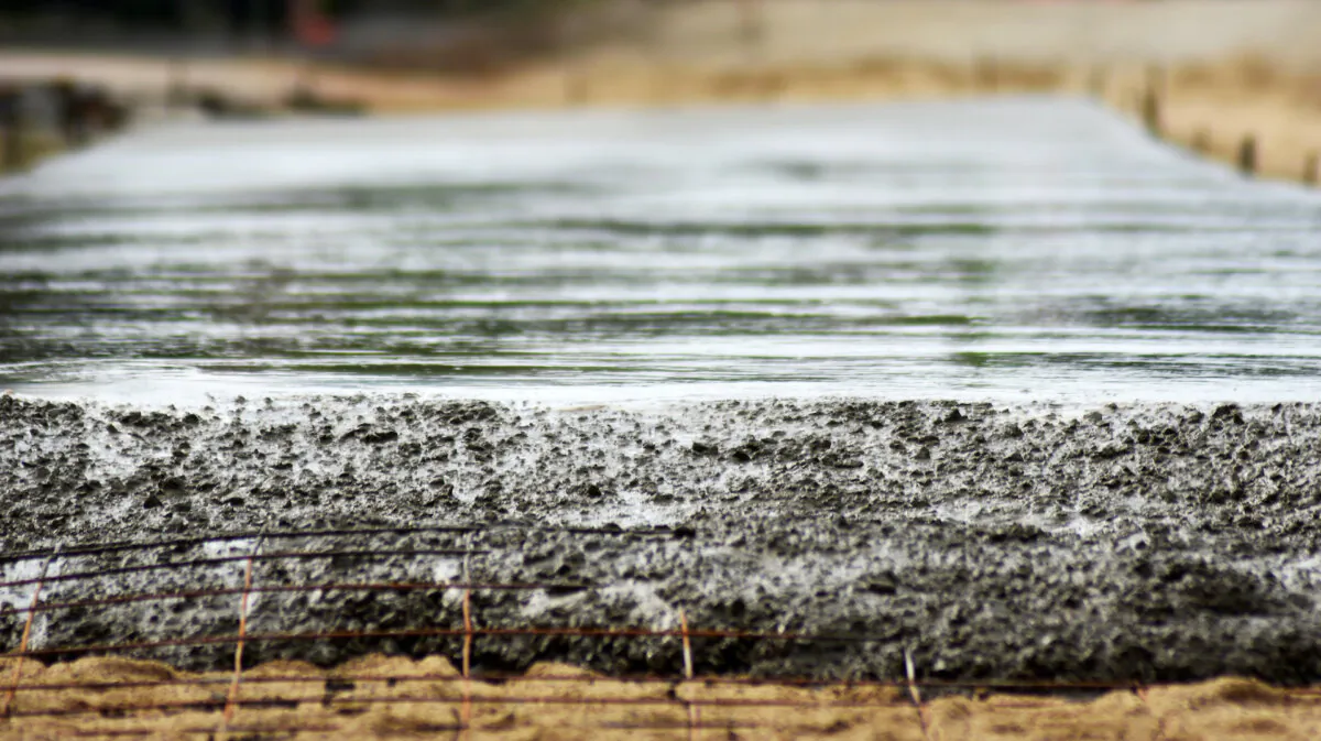 Reinforcing steel rods should be embedded in the concrete, just a couple of inches below the surface. (somratana/Shutterstock)