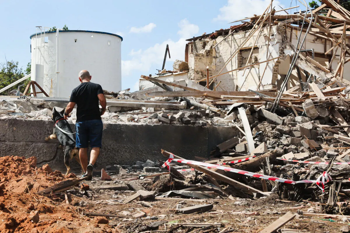 A man and a dog check the rubble of a destroyed building in the aftermath of an Iranian missile attack, in Hod HaSharon, Israel on Oct. 2, 2024. (Jack Guez/AFP via Getty Images)