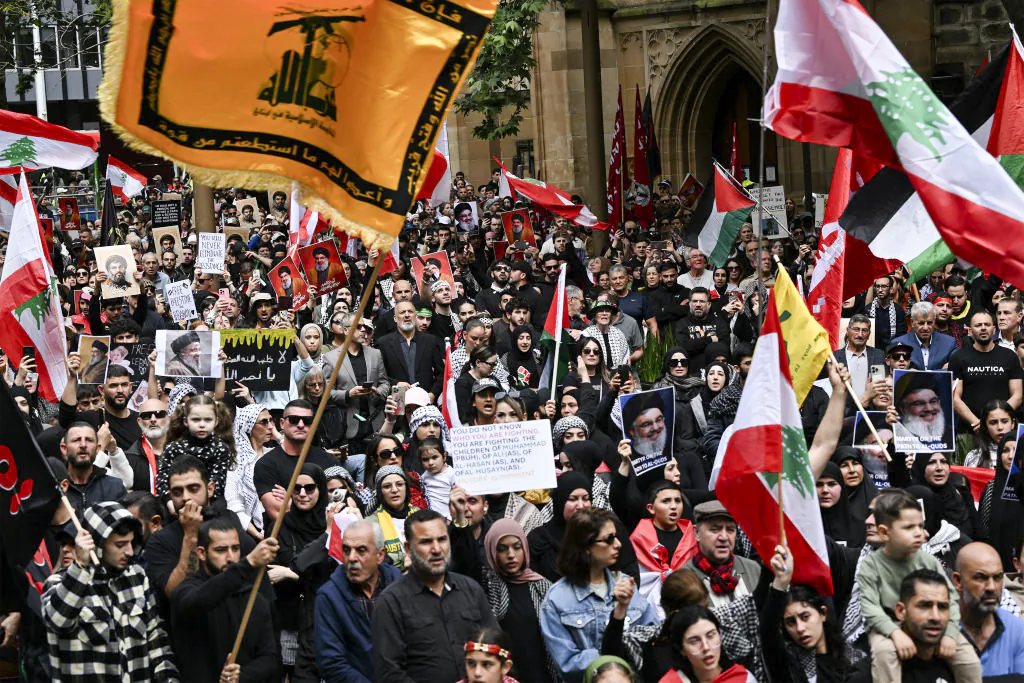 Hundreds of demonstrators hold flags and pictures of Hassan Nasrallah, late leader of the Lebanese group Hezbollah, at a protest rally in the central business district of Sydney, Australia, on Sept. 29, 2024. (Saeed Khan/AFP via Getty Images)