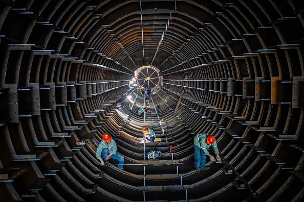 Employees work on a steel tube tower production line at a factory in Haian, in eastern China's Jiangsu Province, on Sept. 1, 2024. (STR/AFP via Getty Images)