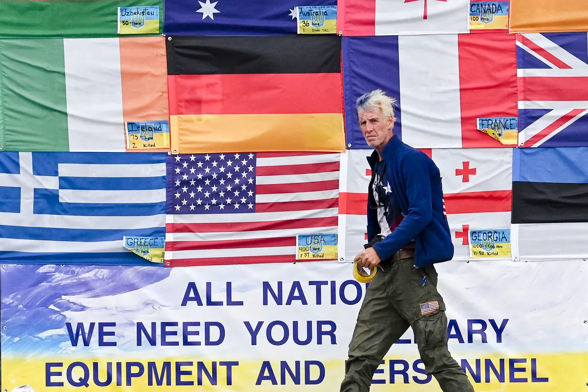 U.S. citizen Ryan Wesley Routh sticking up national flags of the countries helping Ukraine in Kyiv, Ukraine, on June 23, 2022. U.S. media said it was Routh who was arrested after Secret Service agents "opened fire on a gunman" carrying an AK-47 style rifle near the boundary of Donald Trump's Florida golf course where the former president was golfing on Sept. 15, 2024. (SERGEI SUPINSKY/AFP via Getty Images)